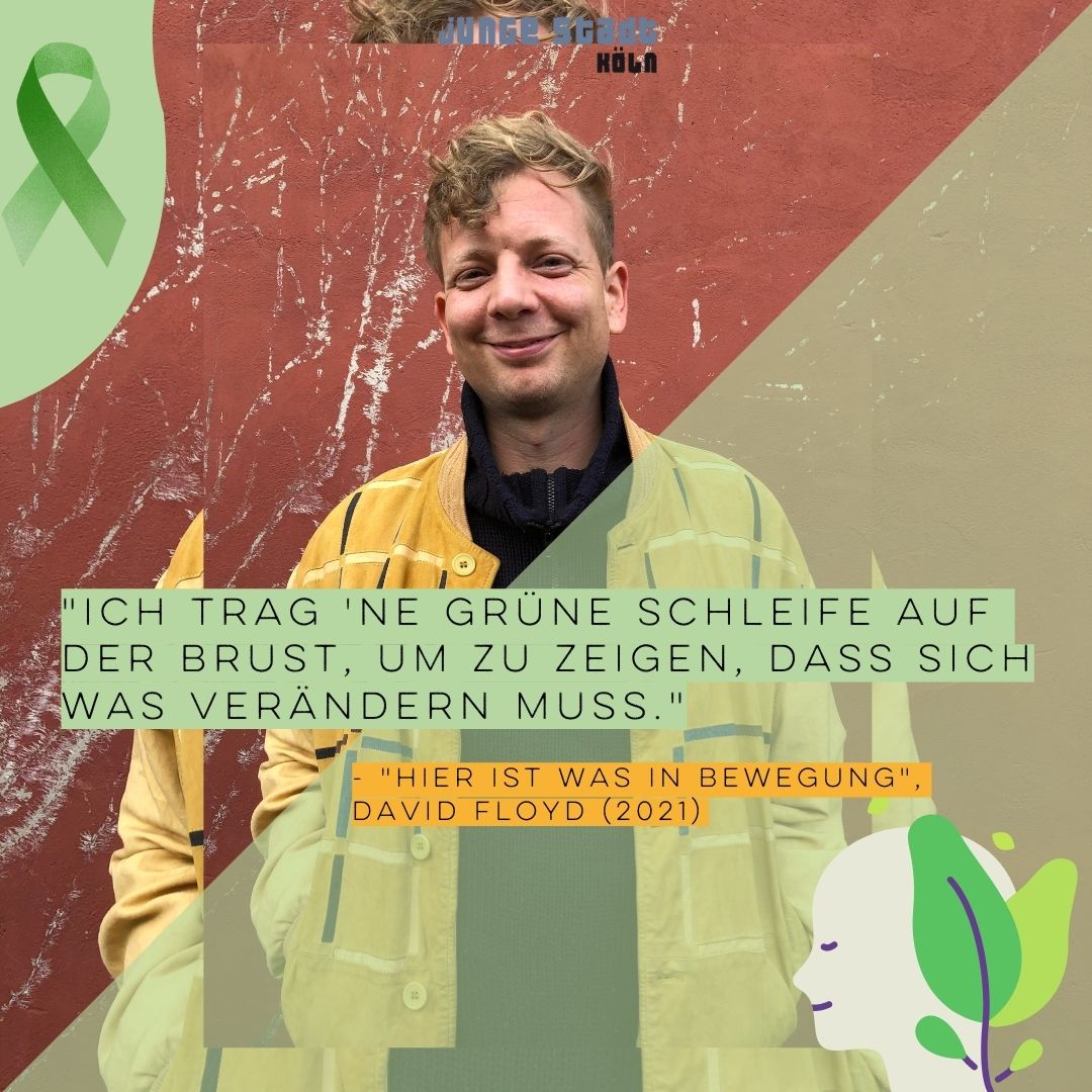 In der Mitte des Bildes steht David Floyd vor einer Wand. Oben links im Bild ist die Grüne Schleife. Unten rechts ist eine Zeichnung von einem Kopf-Profil. Zwei Pflanzenblätter ranken um den Hinterkopf. Im Vordergrund des Bildes steht: “Ich trag ‘ne Grüne Schleife auf der Brust, um zu zeigen, dass sich was verändern muss. - Hier ist was in Bewegung, David Flyod (2021).”